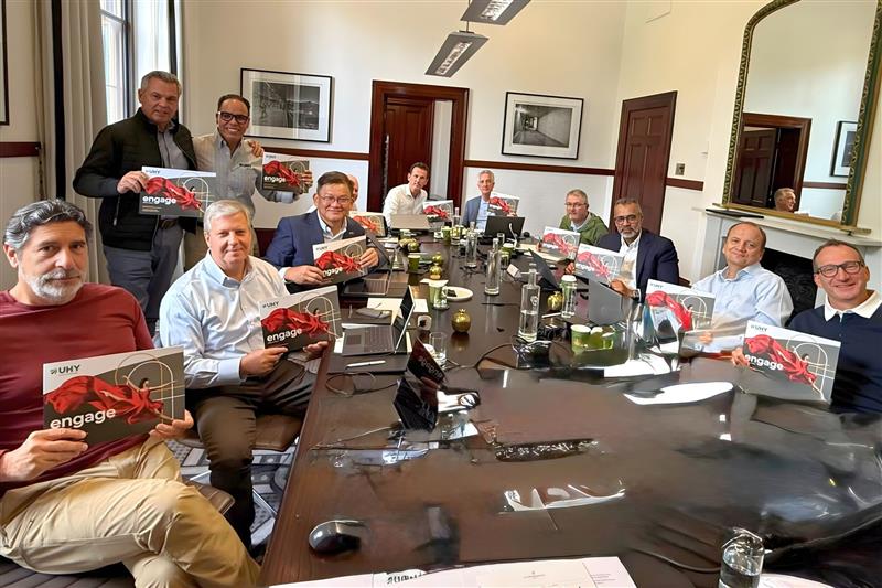 UHY Board holding the UHY Engage 2025 Publication